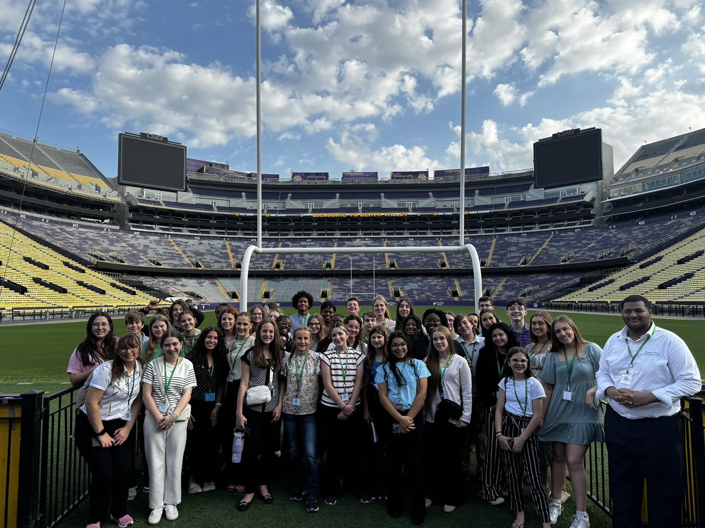 A group of people posing inside a football stadium.